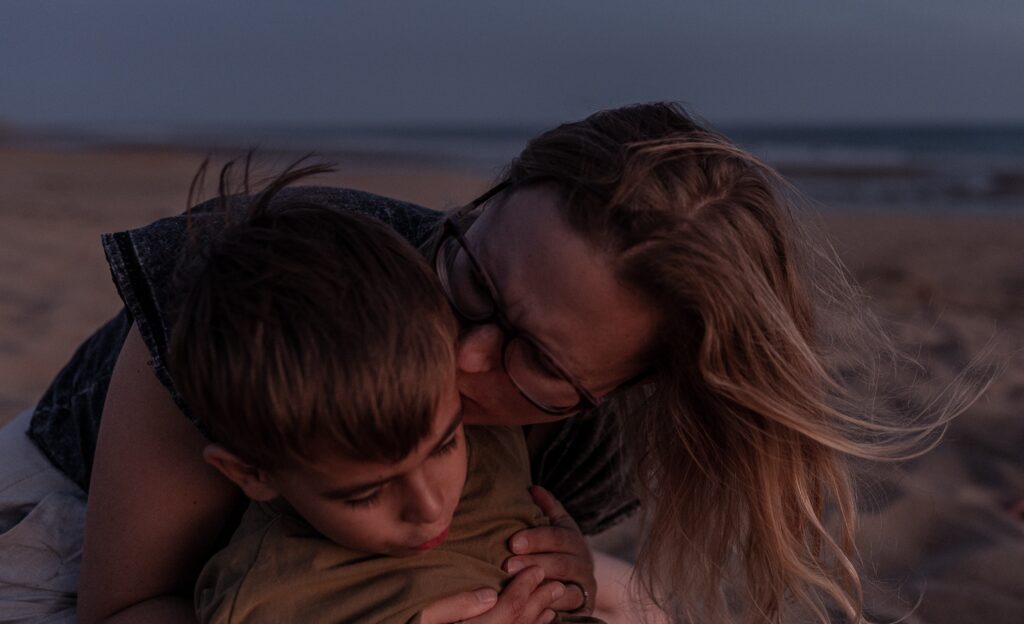 Sarah Eisermann küsst am Strand ihren Sohn